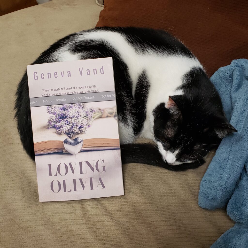 photo of cat and papberback copy of Loving Olivia
